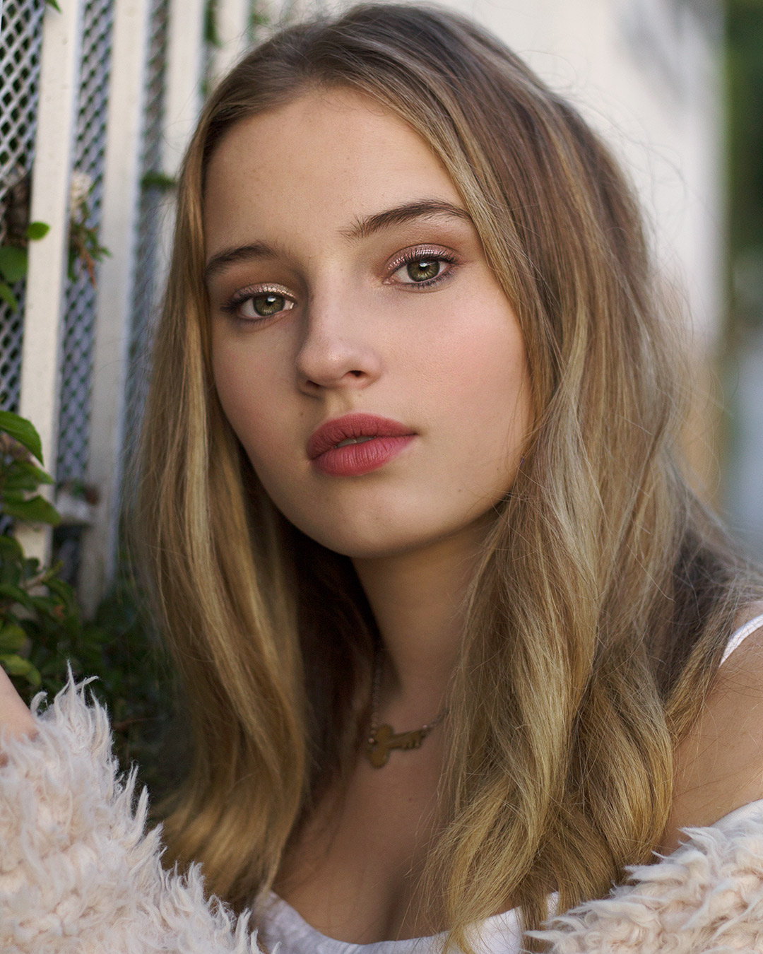professional photo by nate torres of woman by white fence